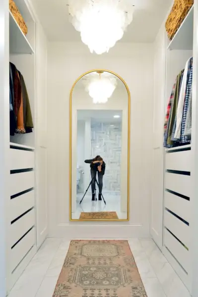 Volledig shot van de nieuwe Ikea Pax-kast met sherry en statief in de gouden West Elm Arch-spiegel