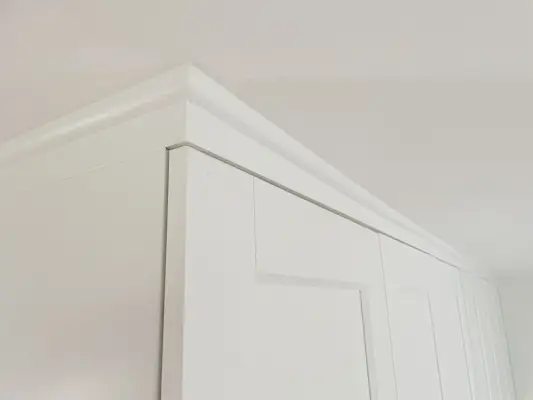 Afgewerkte en geverfde kwartronde lijst waardoor Ikea Pax-kasten er ingebouwd uitzien