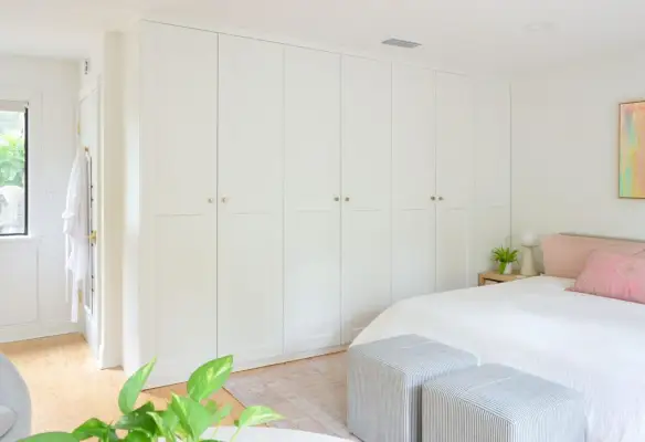 Rij Ikea Pax-garderobekasten in de slaapkamer met gouden knoppen