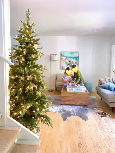 Kerstboom onversierd in de keuken met kinderen die ornamenten op de achtergrond grijpen