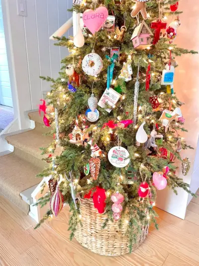 Detail van ornamenten op smalle kerstboom in keuken in rieten mand