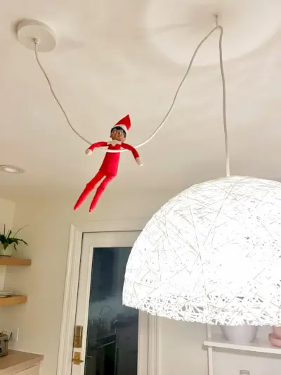 Elf op de plank hangend aan hanglampsnoer in de keuken