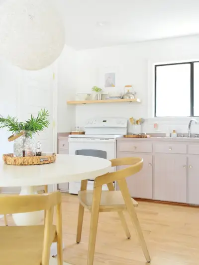 Eenvoudige witte keuken met mauve Artsy Pink kasten en voetstuktafel