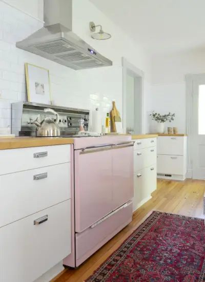 strandhuiskeuken met roze fornuis en witte metro-achterwand