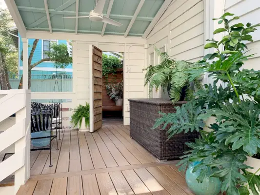 Overdekte veranda met blauw plafond en open deur naar buitendouche