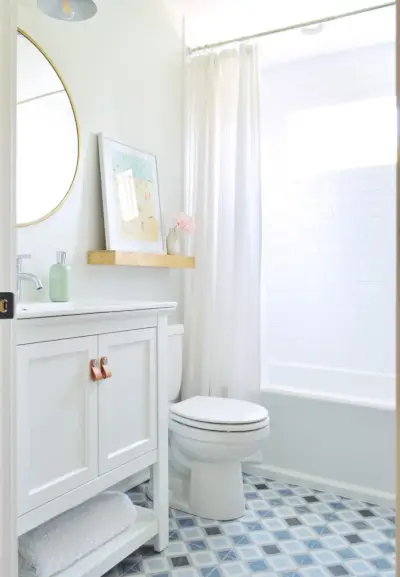 Duplexbadkamer met witte muren, metrotegeldouche en tegelvloer met blauw patroon