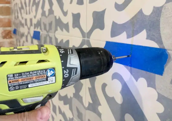 Boren door tegelachterwand met behulp van een gemarkeerde plek met schilders Tpae