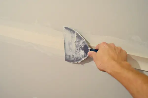 gipsplaatmes maakt de tape glad in gipsplaattape en de onderste laag modder