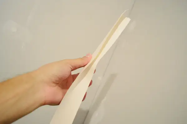 met de hand opvouwbare gipsplaattape langs de naad voordat u deze in de hoek drukt