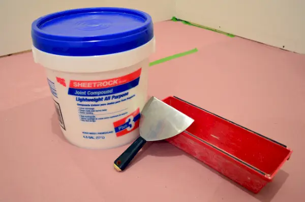 gipsplaatmodder of gipsplaten verbinden het mengsel met een spackle-mes en een modderpan