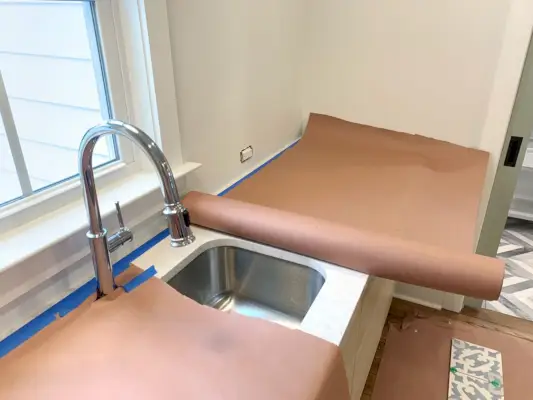 Rood harspapier dat het aanrecht beschermt vóór installatie van de backsplash