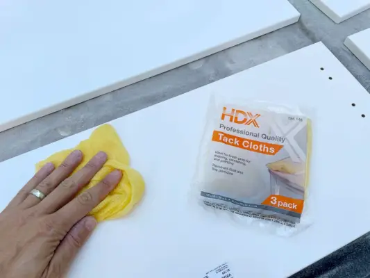 Stof afvegen witte kastdeur met kleverige doek