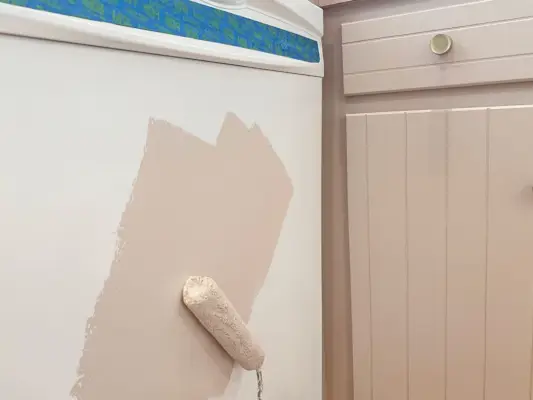 Paarse verf op witte vaatwasser rollen met een kleine schuimroller