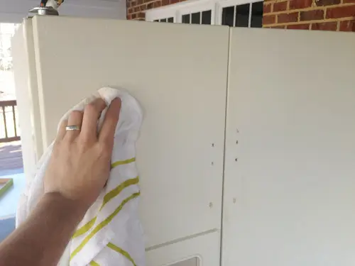 Maak de koelkastdeur schoon van schuurstof voordat u gaat schilderen