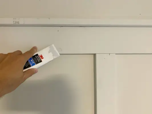 Spackling-gereedschap gebruiken om spijkergaten aan boord en lat te vullen