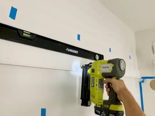 Gebruik een spijkerpistool om de bovenste rail van het bord en de lat te installeren