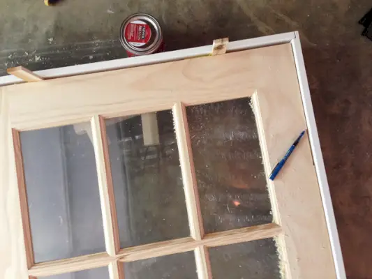 Droogmontage DIY-stijlkit rond glazen paneeldeur met behulp van vulplaten als afstandhouders