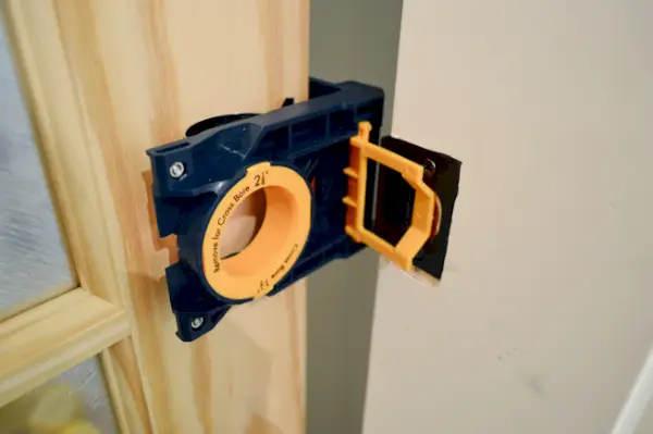 Ryobi deurslotset, vastgeklemd aan een onafgewerkte deur om de locatie van de knop en de sluitplaat te markeren