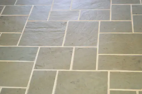 close-up van schone voeg tussen leistenen tegelvloer na toepassing van Polyblend Grout Renew