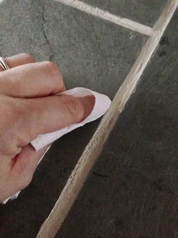 veegrand van PolyBlend Grout Vernieuw de toepassing op vuile voeg met schoon keukenpapier