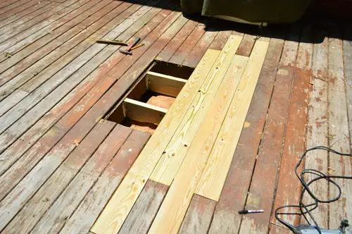 Gat in houten dek gerepareerd met nieuwe planken