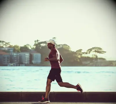A man running alone next to a lake