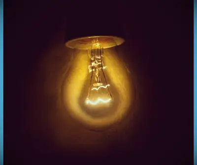 A dimly lit filament light bulb inventeb by Thomas Edison