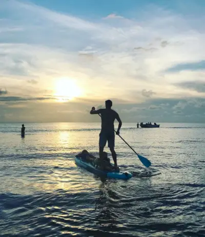 paddleboarden met kinderen bij zonsondergang op het strand van Cape Charles