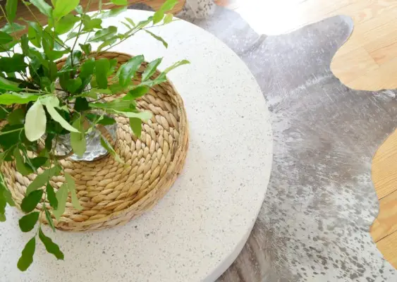 Bovenaanzicht van CB2 Terrazzo-buitensalontafel op metalen koeienhuidkleed