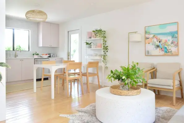 Zithoek met ronde salontafel naast paarse Ikea-keuken