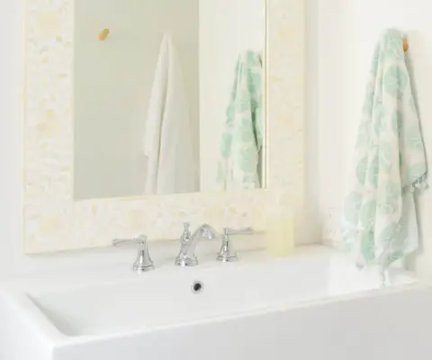 Lichte moderne badkamer met grote witte wastafel en spiegel met beeninleg