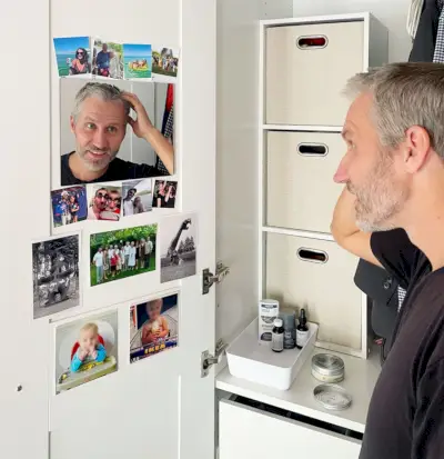 John maakt zich klaar in de kastspiegel in de Ikea Pax-kledingkast