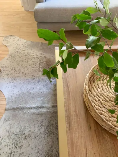 Üstte pirinç aksanı gösteren ahşap sehpanın kapalı çekmecesi