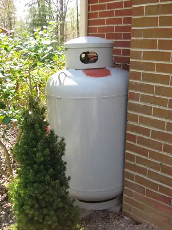 Tuğlaya uyacak şekilde kırmızı boyalı arkasındaki metal yardımcı propan tankı