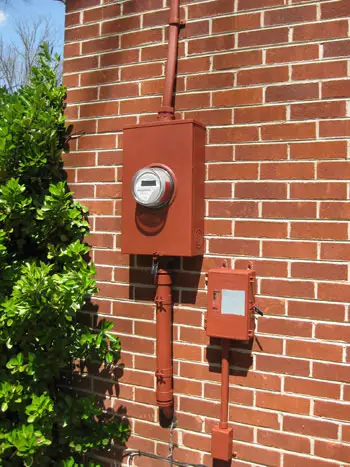 Evin tuğla kırmızısıyla uyum sağlayacak şekilde kırmızıya boyanmış elektrik sayacı kullanım kutusu