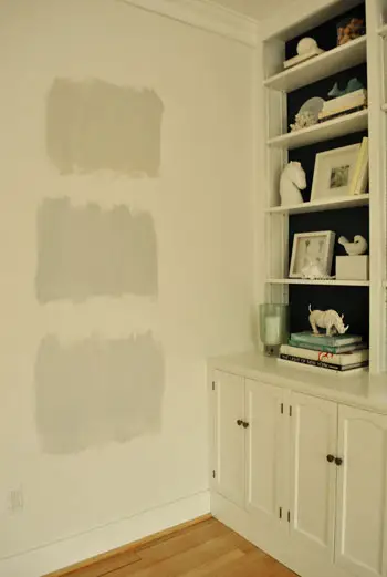 testen van grijze verfmonsterkleuren op de muur tijdens nachtelijk licht