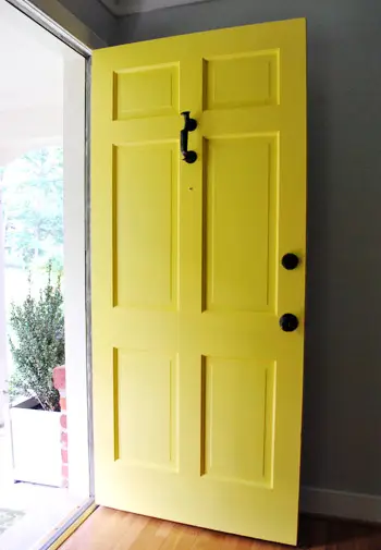 Puerta de entrada amarilla abierta al rancho de ladrillos en venta