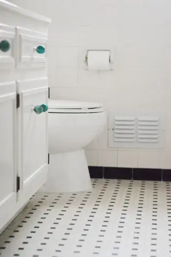 Baño con azulejos blancos y negros de tejido de cesta vintage