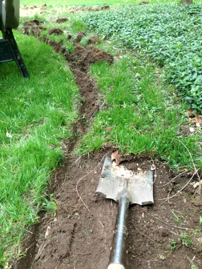 Gras rond het mulchbed uitgraven