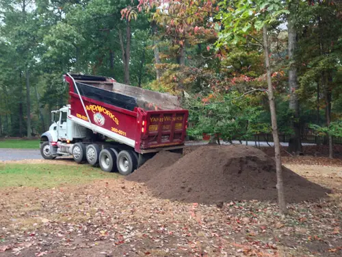 Dumpen van vuilvrachtwagens in de tuin