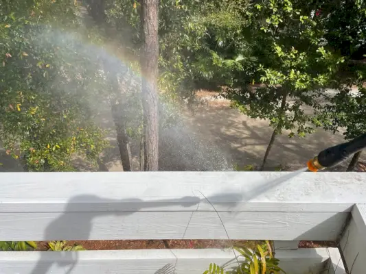 Regenboog ontstaan door overspray tijdens het hogedrukreiniging van relingen aan dek