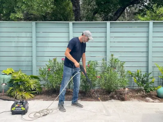 John hogedrukreiniger op het zwembadterras met Ryobi elektrische wasmachine