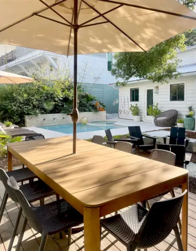 Metalen eettafel met parasol in het zwembad in de achtertuin