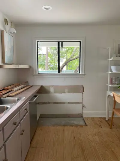 Foto van de binnenkant van de keuken toen de kasten werden verwijderd om plaats te maken voor een nieuwe deur
