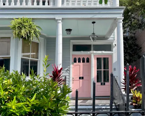 Zuidelijk huis met roze deuren en haintblauw verandaplafond