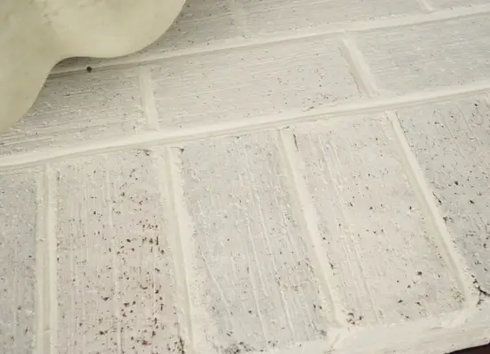 Detail van een open haard in witgekalkte baksteen