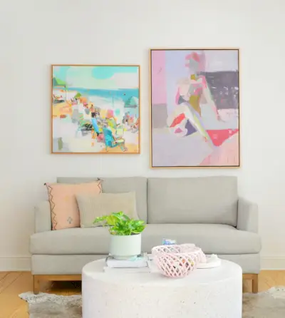 Loveseat met kleurrijke schilderijen op zuiver witte muren