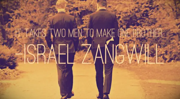 Two brothers in Zegna tuxedos talking before the older brother
