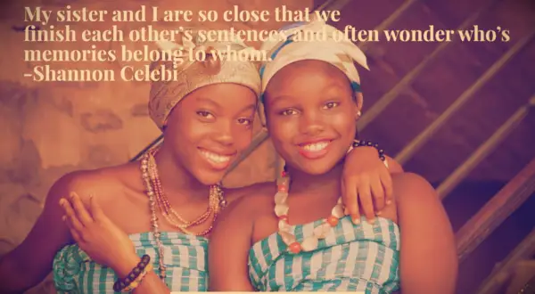 Two sisters from Lagos in matching dresses and headscarves smile together