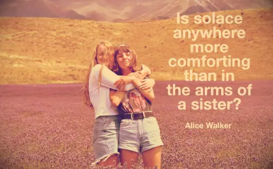 Two sisters hugging in a field of wild mountain lavender in Colorado
